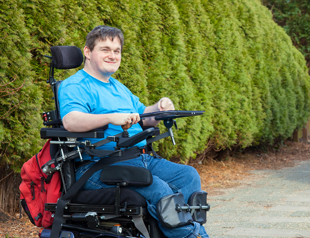 A smiling man in a wheelchair, showcasing joy and positivity in his expression