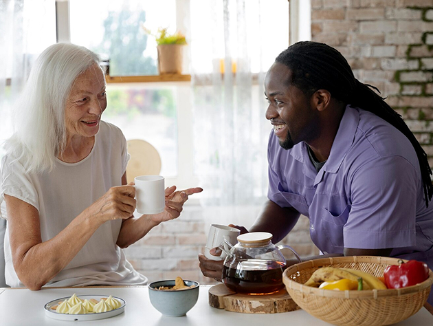 A man and woman relax at a table, sipping coffee and engaging in conversation