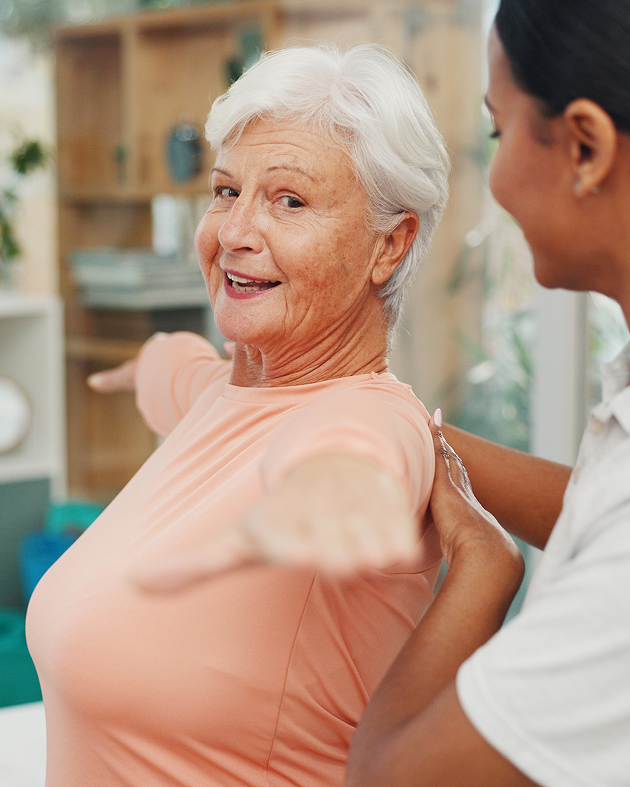 A woman assists an older woman by supporting her arm, demonstrating care and guidance