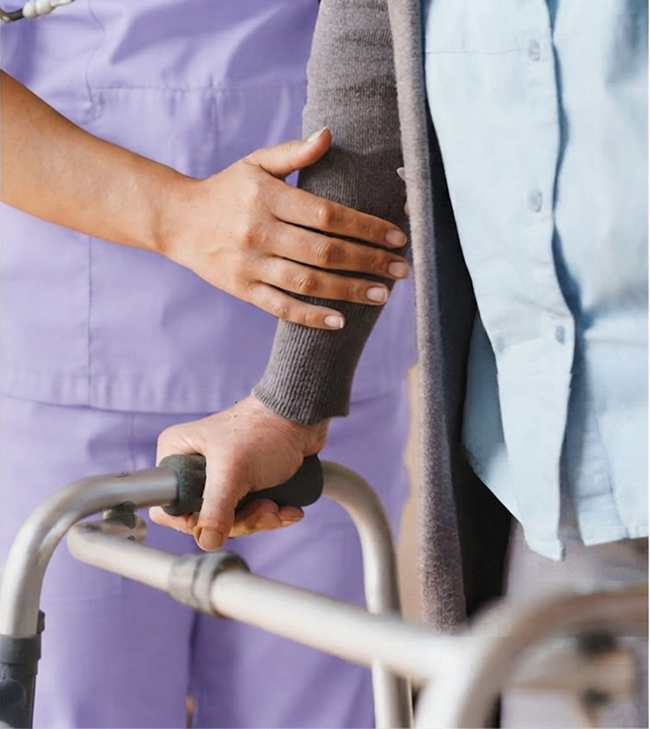 A nurse gently holds the arm of an elderly patient, providing support and care in a healthcare setting