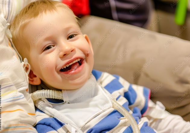 A young boy smiles happily while sitting comfortably on a couch