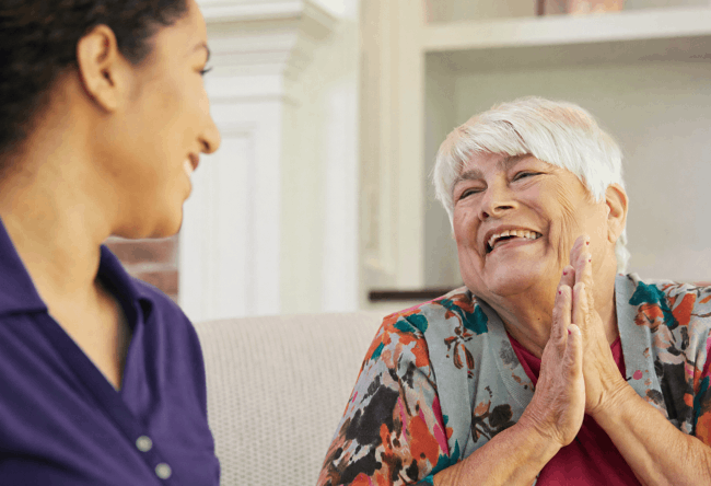A woman engages in conversation with an older woman, both appearing attentive and interested in the discussion