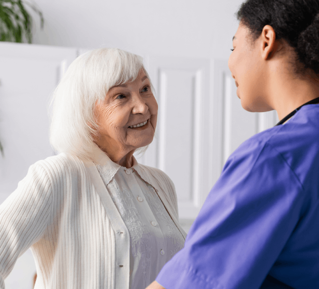 A woman engaged in conversation with an older woman, both appearing attentive and interested in the discussion
